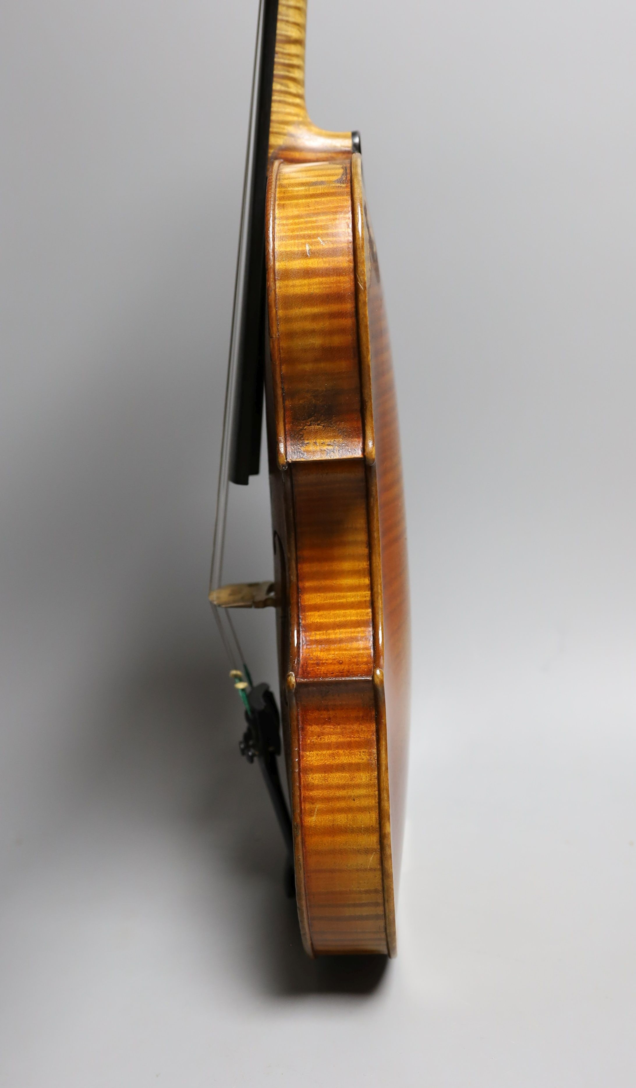 A 19th century violin labelled JB Guadagnini, back measures 35cm, with two bows, one silver-mounted.